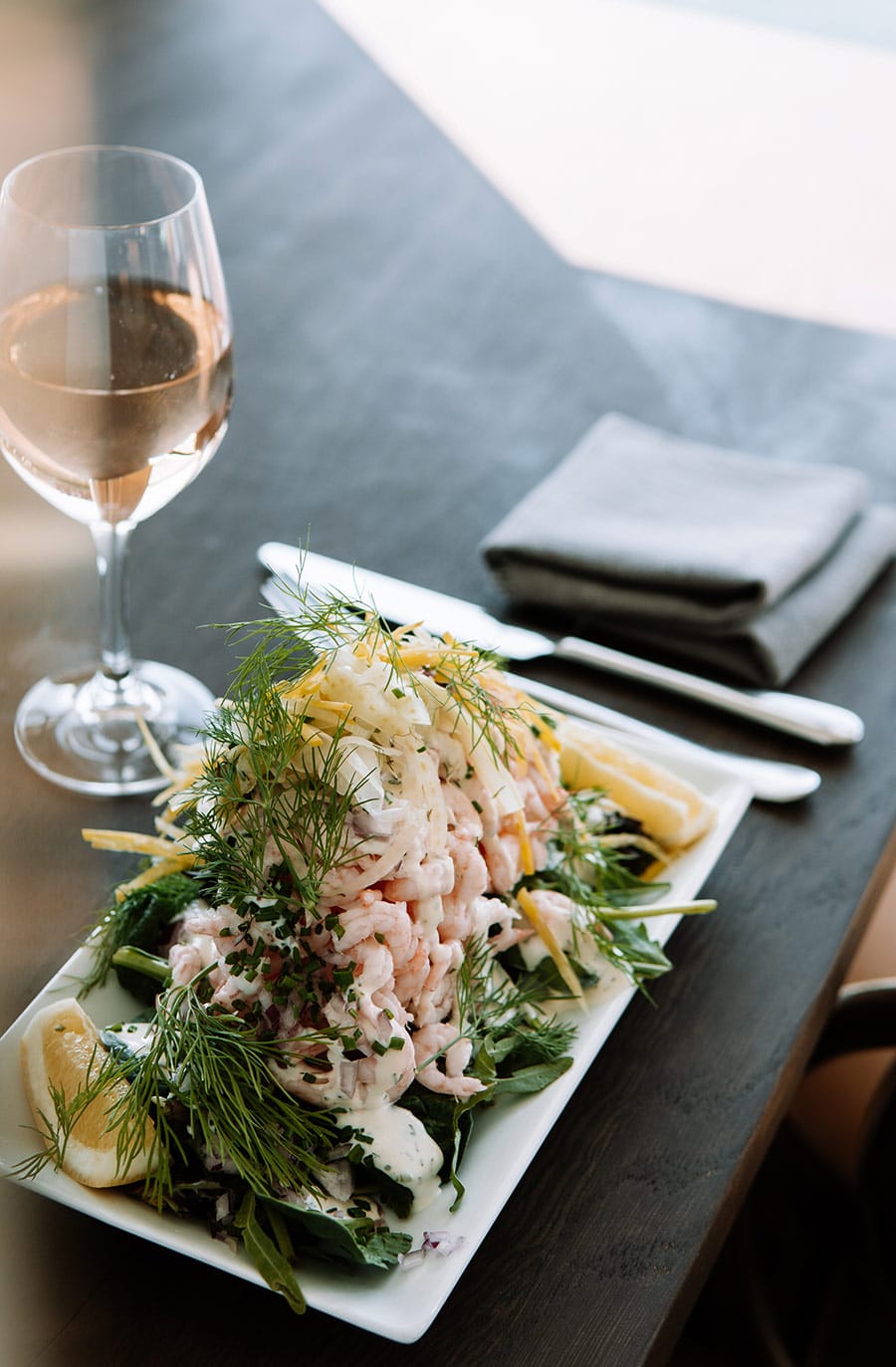 Färsk skaldjursrätt serverad med vin, citron och dill på Skärets Krog. Perfekt för en avkopplande lu.